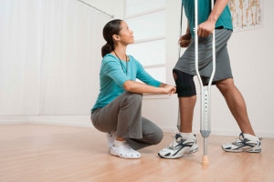 Physical therapist helping a patient with crutches